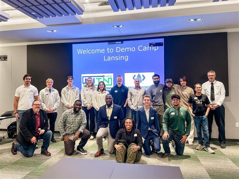 DemoDay Lansing event picture showing participants in a group photo at the front of the room.